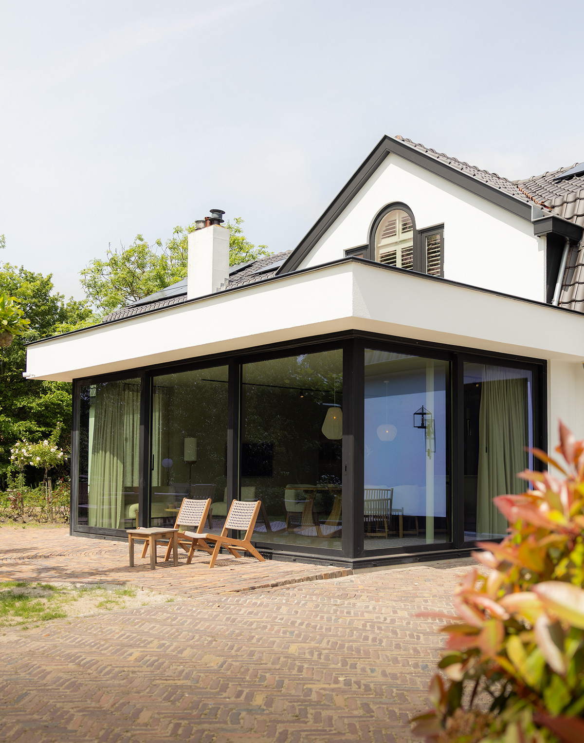 Renovatie in Heenvliet: woning met witte aanbouw en glazen pui