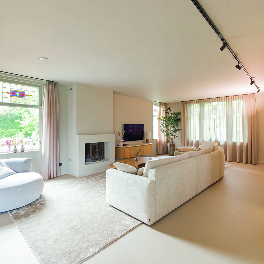 Lichte woonkamer met open haard na renovatie in Heenvliet
