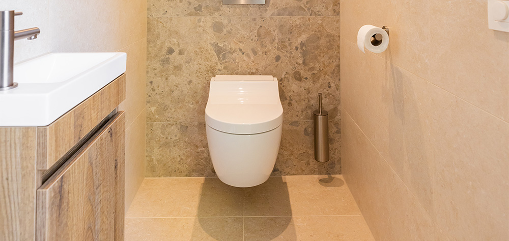 Toiletruimte met hangtoilet en natuursteen wandtegels