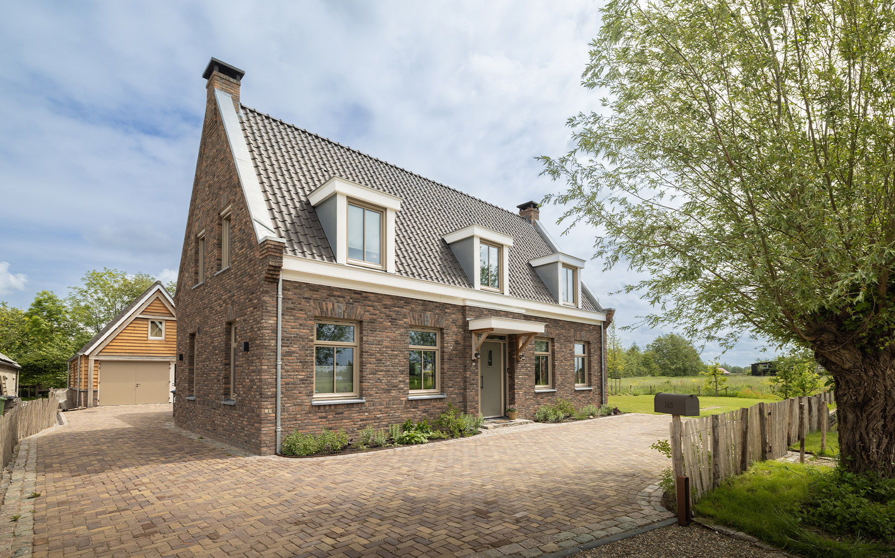 Vrijstaande nieuwbouwwoning van baksteen met dakkapellen