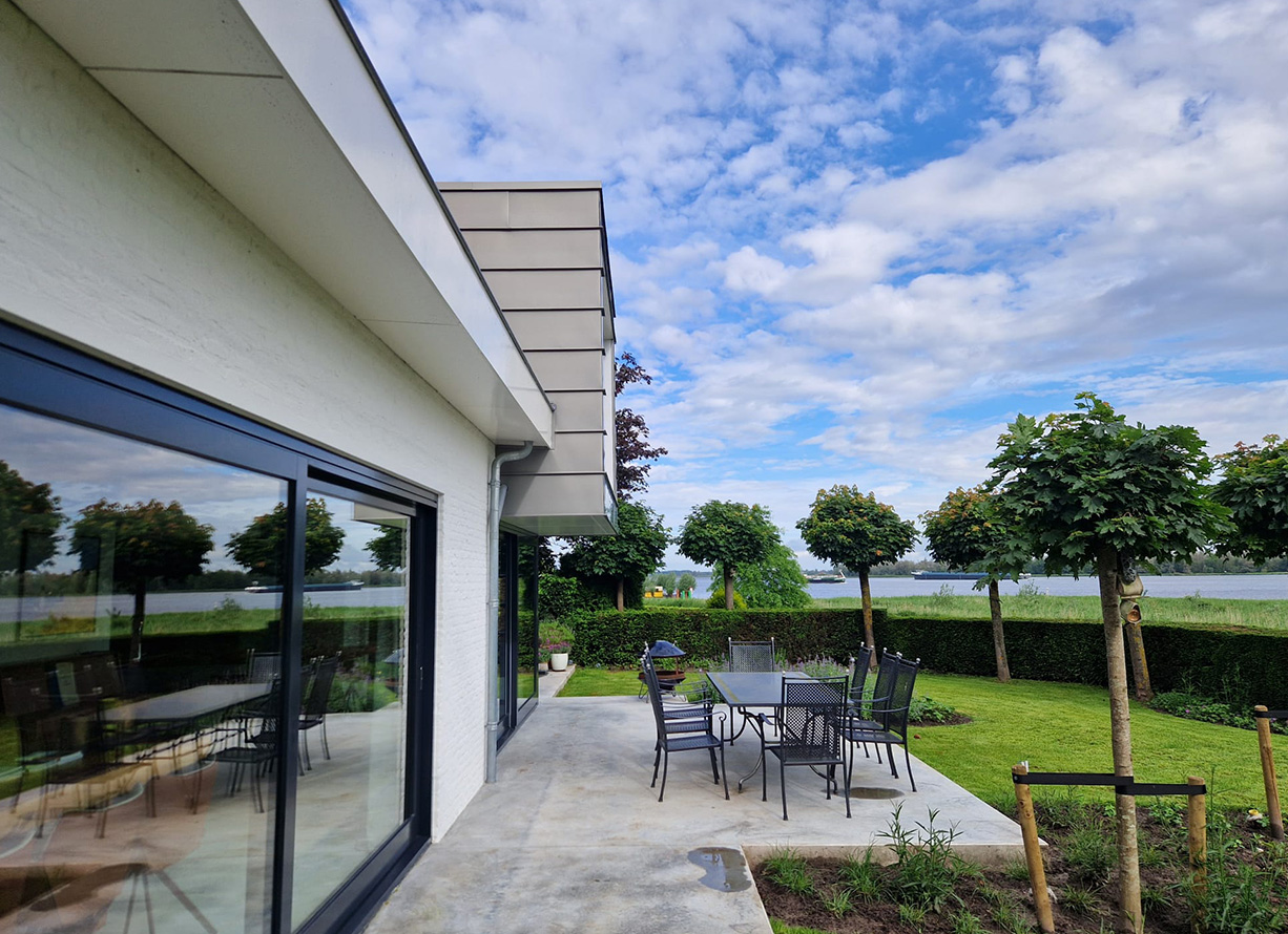 Terras en tuin gezien vanaf de glazen pui in Lage Zwaluwe