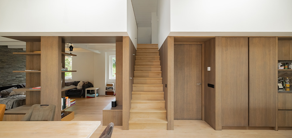 Hal met houten trap en maatwerk kastenwand