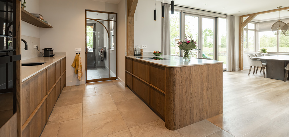 Keuken met houten kookeiland en stalen deur