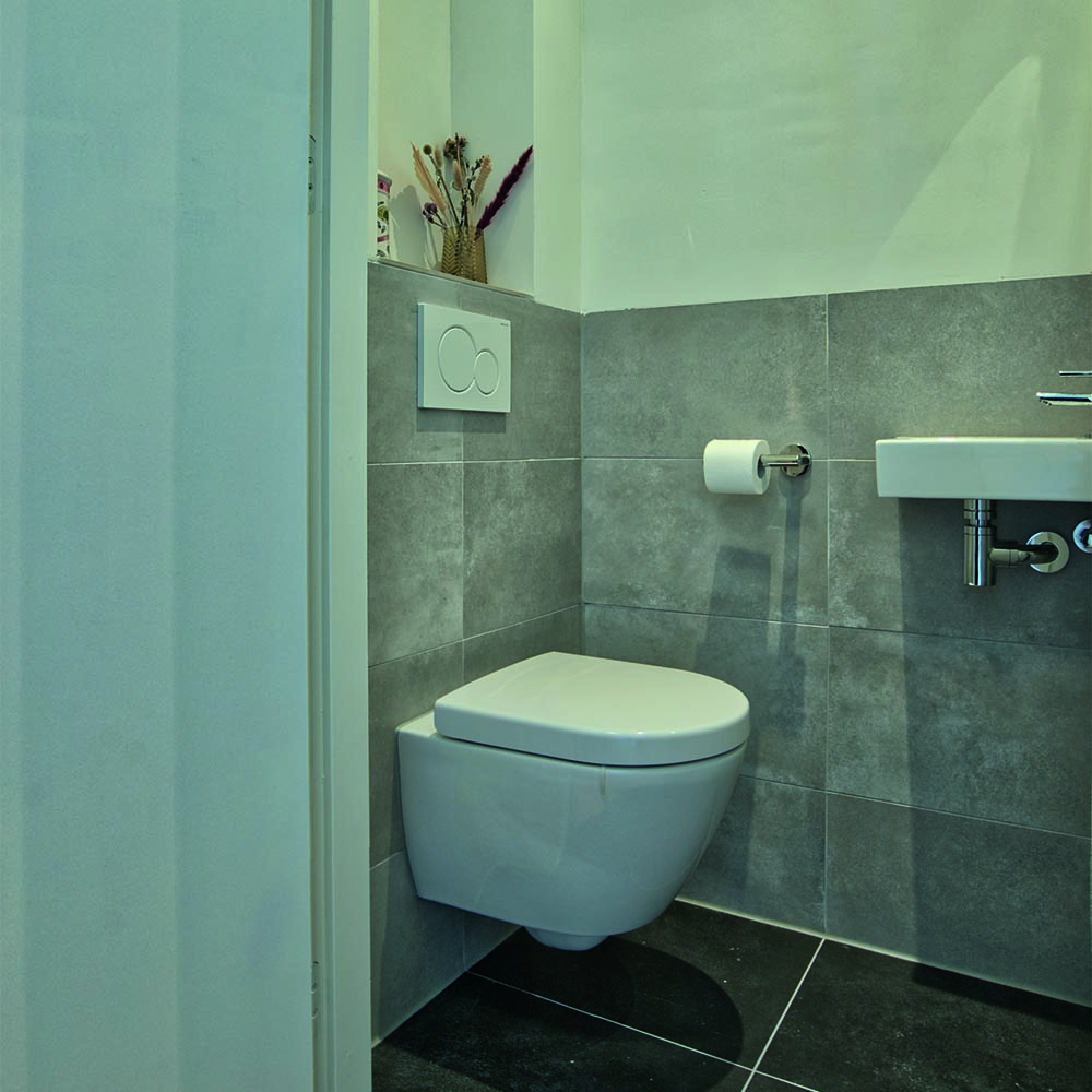 Toilet met grijze wandtegels aan de Johan de Wittlaan