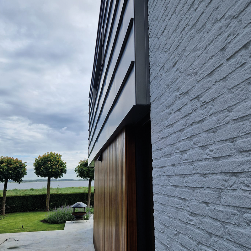 Detail van grijze gevel met houten accent in Lage Zwaluwe
