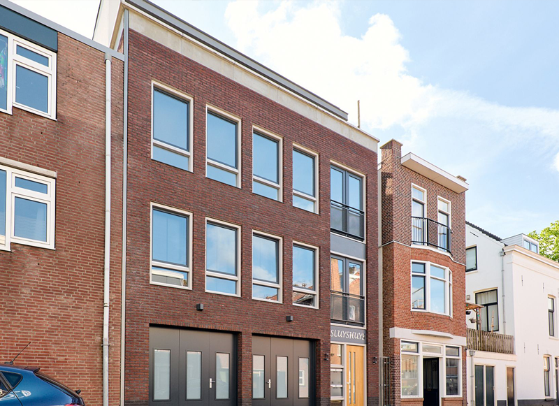 Bakstenen gevel van appartementencomplex aan de Sluisweg in Dordrecht