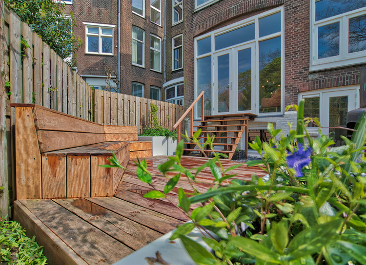 Achtertuin met houten terras en gevel met nieuwe puien aan de Hooidrift in Rotterdam