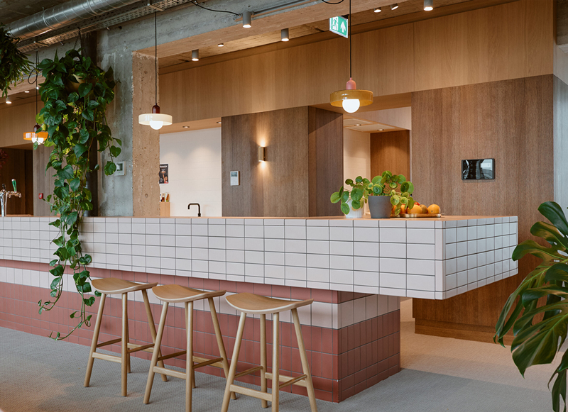 Betegelde bar met hangende planten in kantoor VI Company in Rotterdam