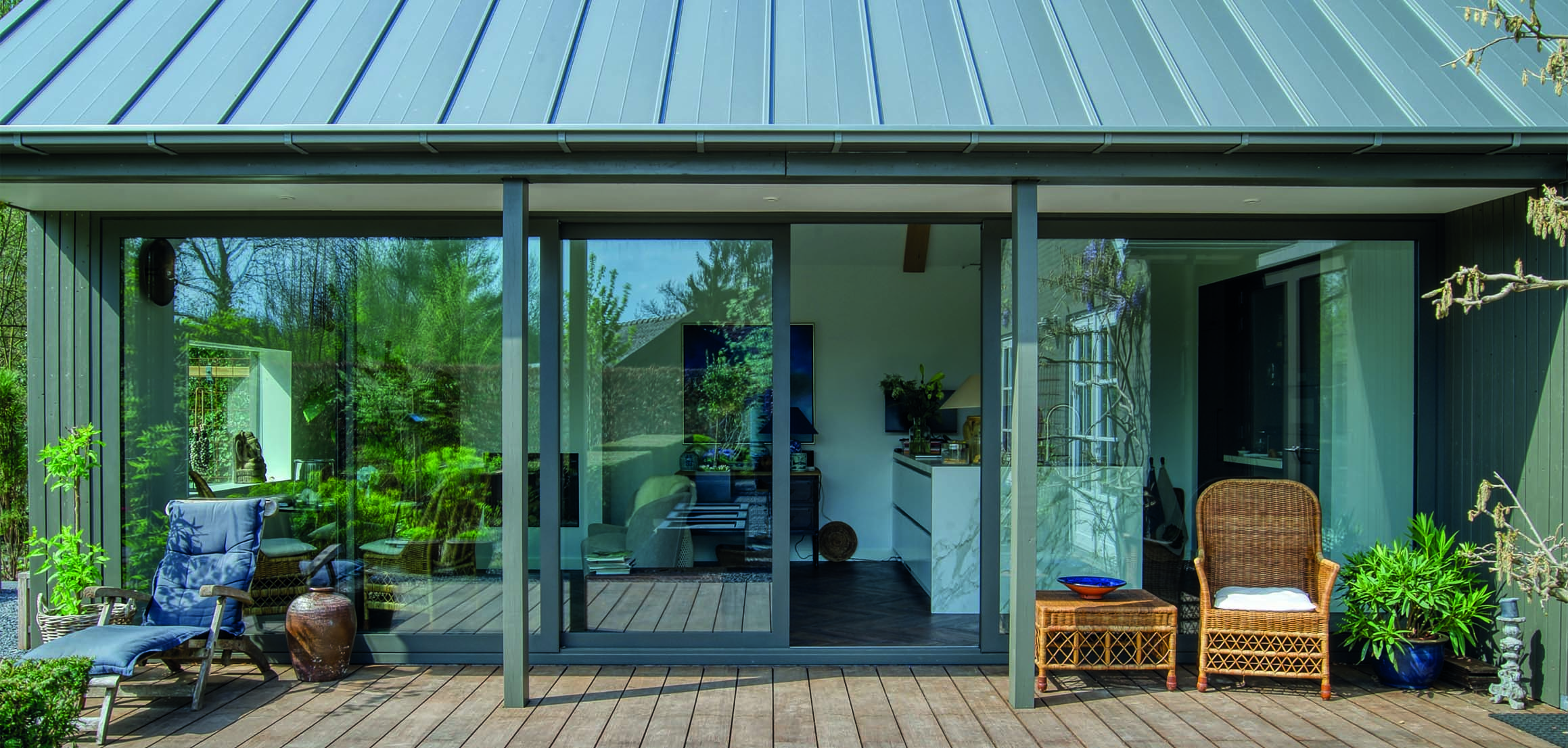 Uitbreiding met glazen schuifpuien en houten terras in Ulvenhout