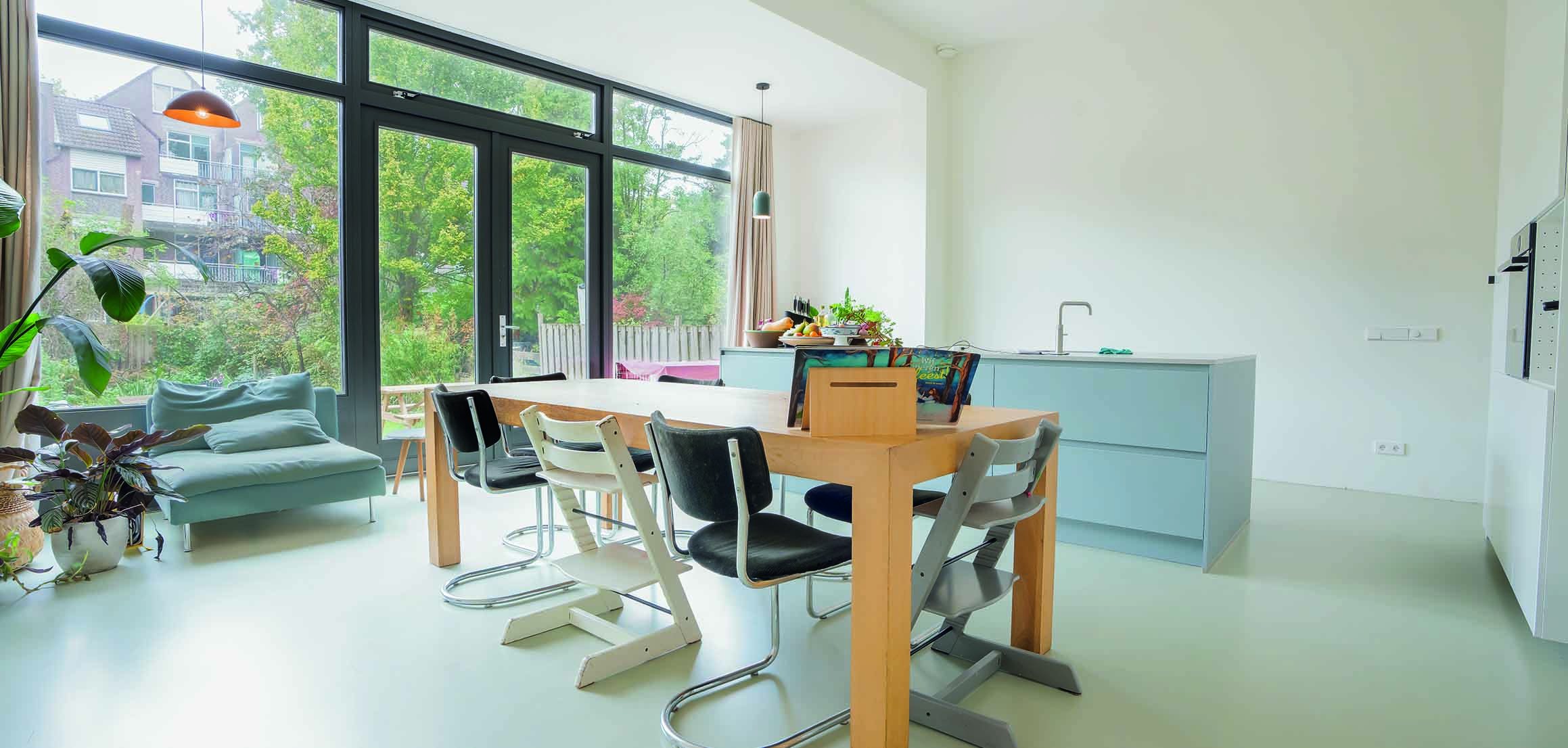 Open keuken en eettafel met glazen pui in nieuwbouwwoning in Rotterdam