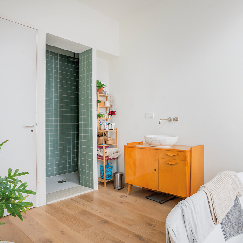 Badkamer met groene tegels en oranje badmeubel in nieuwbouwwoning in Rotterdam