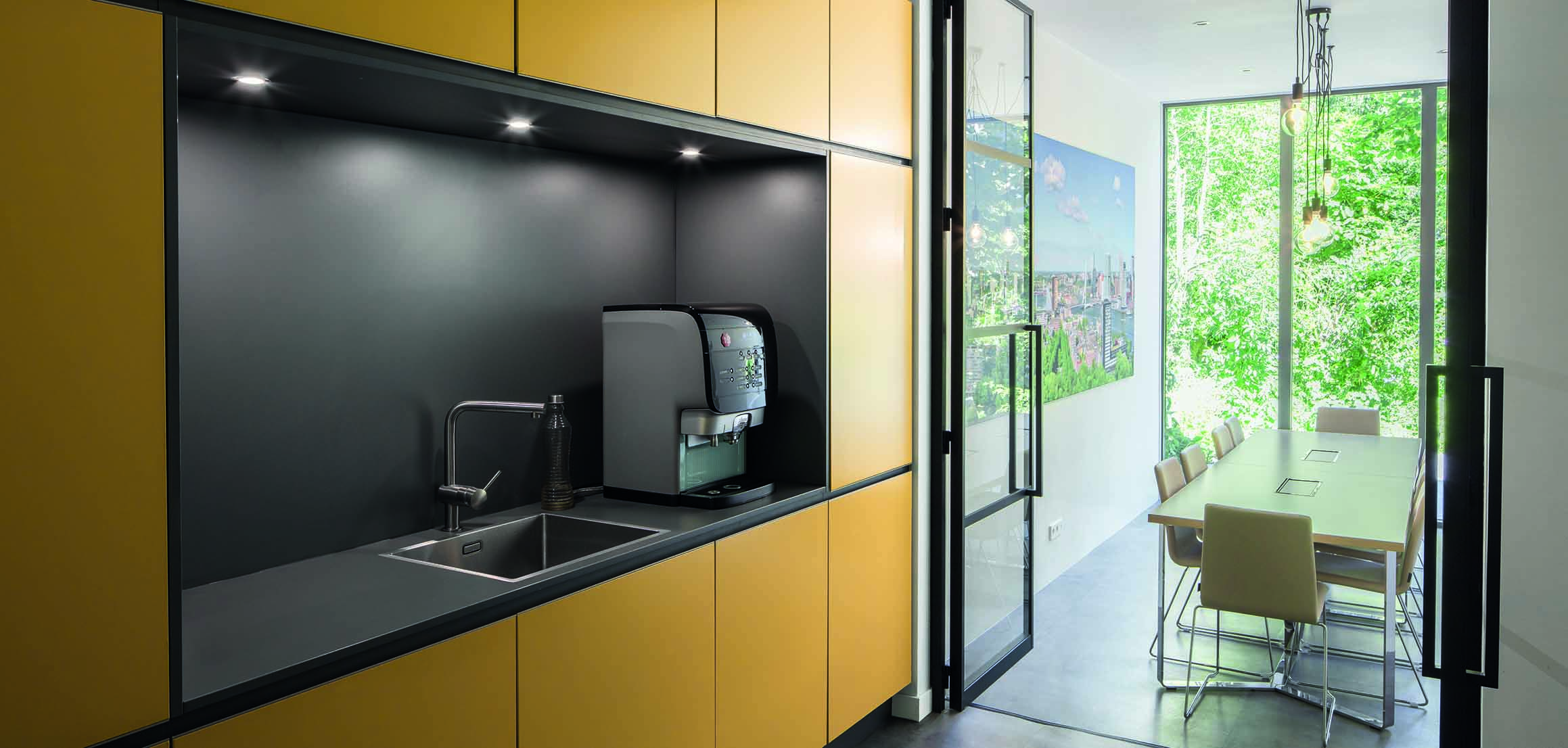 Pantry met gele kasten en koffiemachine in notariskantoor aan de Mathenesserlaan in Rotterdam