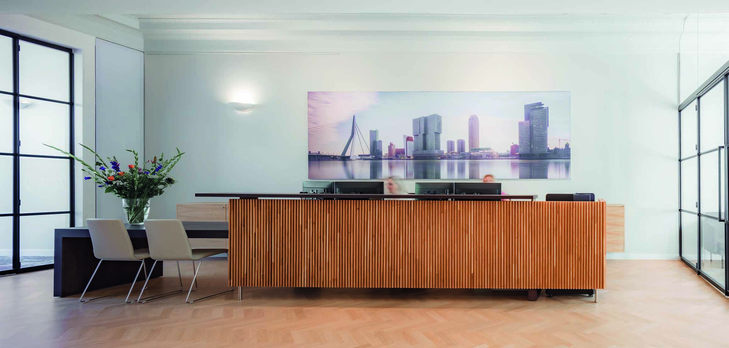 Ontvangstruimte met houten balie en kunstfoto in notariskantoor aan de Mathenesserlaan in Rotterdam