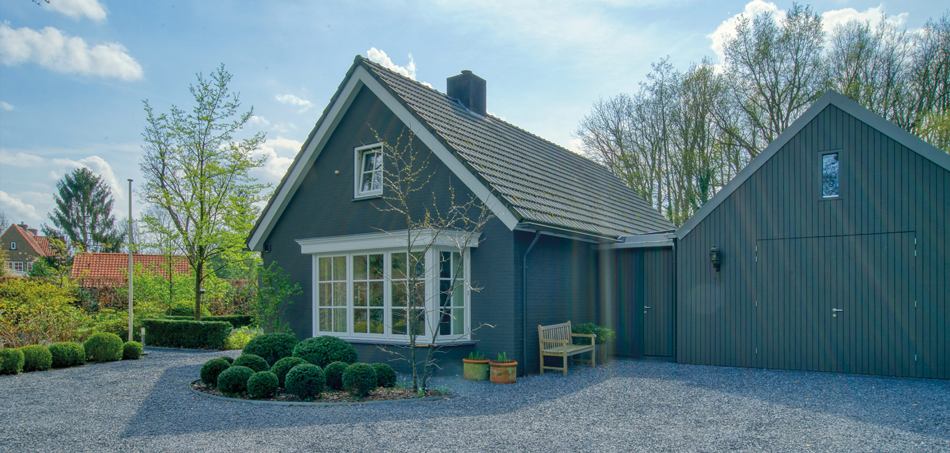 Woning met donkere gevel en bijgebouw in Ulvenhout