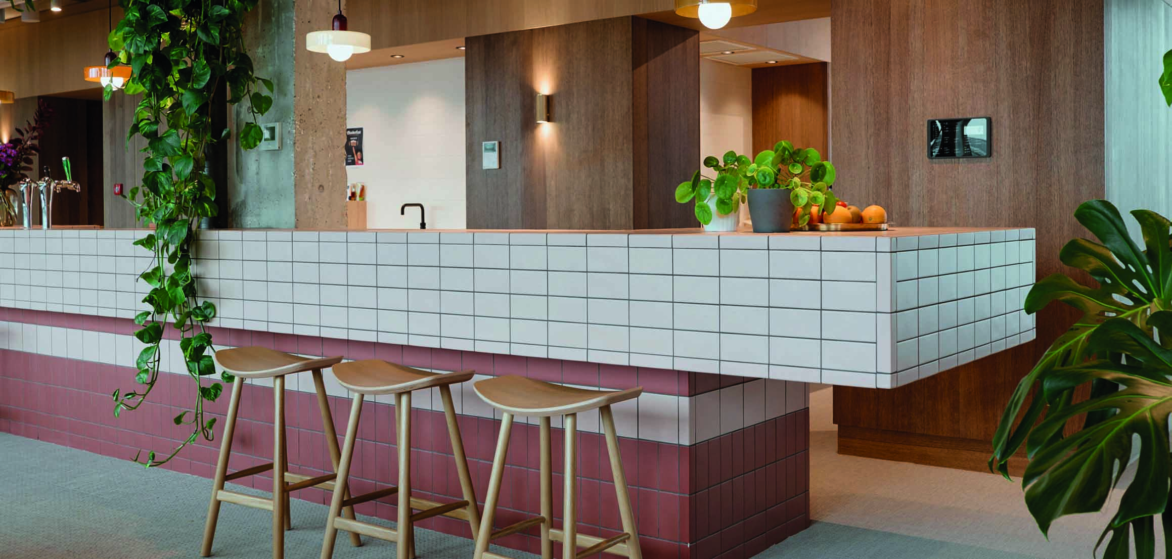 Bar met witte tegels en houten wand in kantoor VI Company in Rotterdam