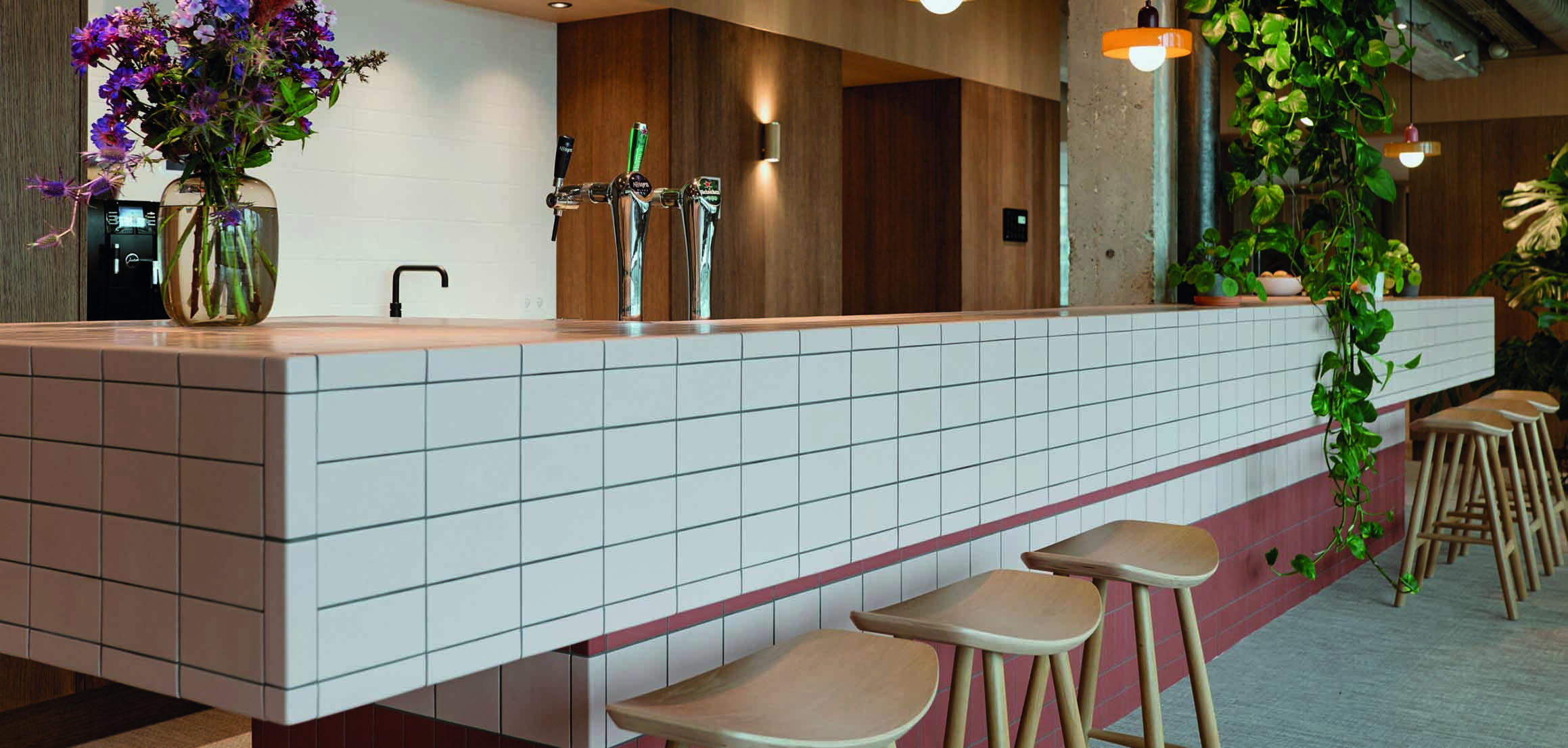 Pantry met betegelde bar en barkrukken in kantoor VI Company in Rotterdam