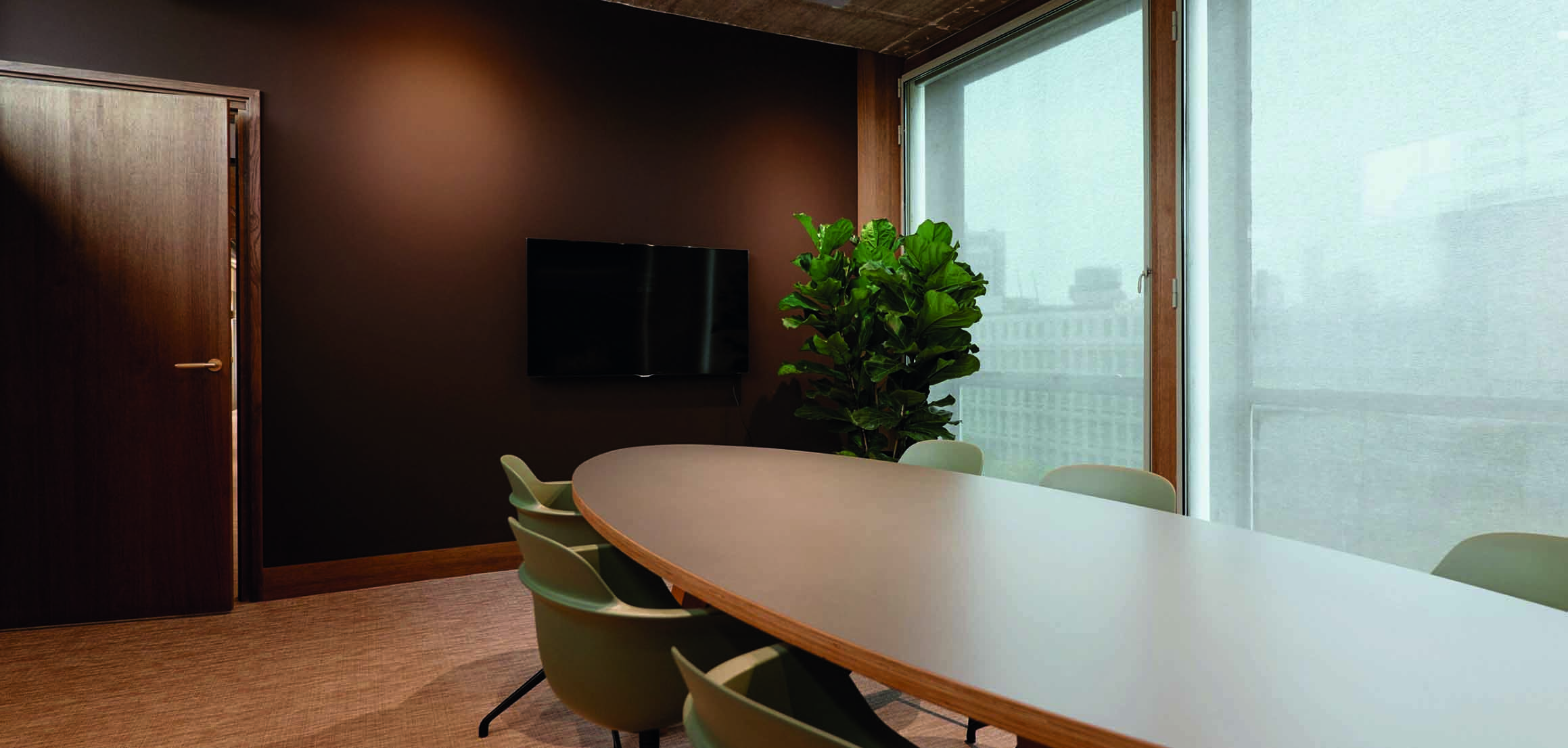 Vergaderruimte met ovale tafel en houten wanden in kantoor VI Company in Rotterdam