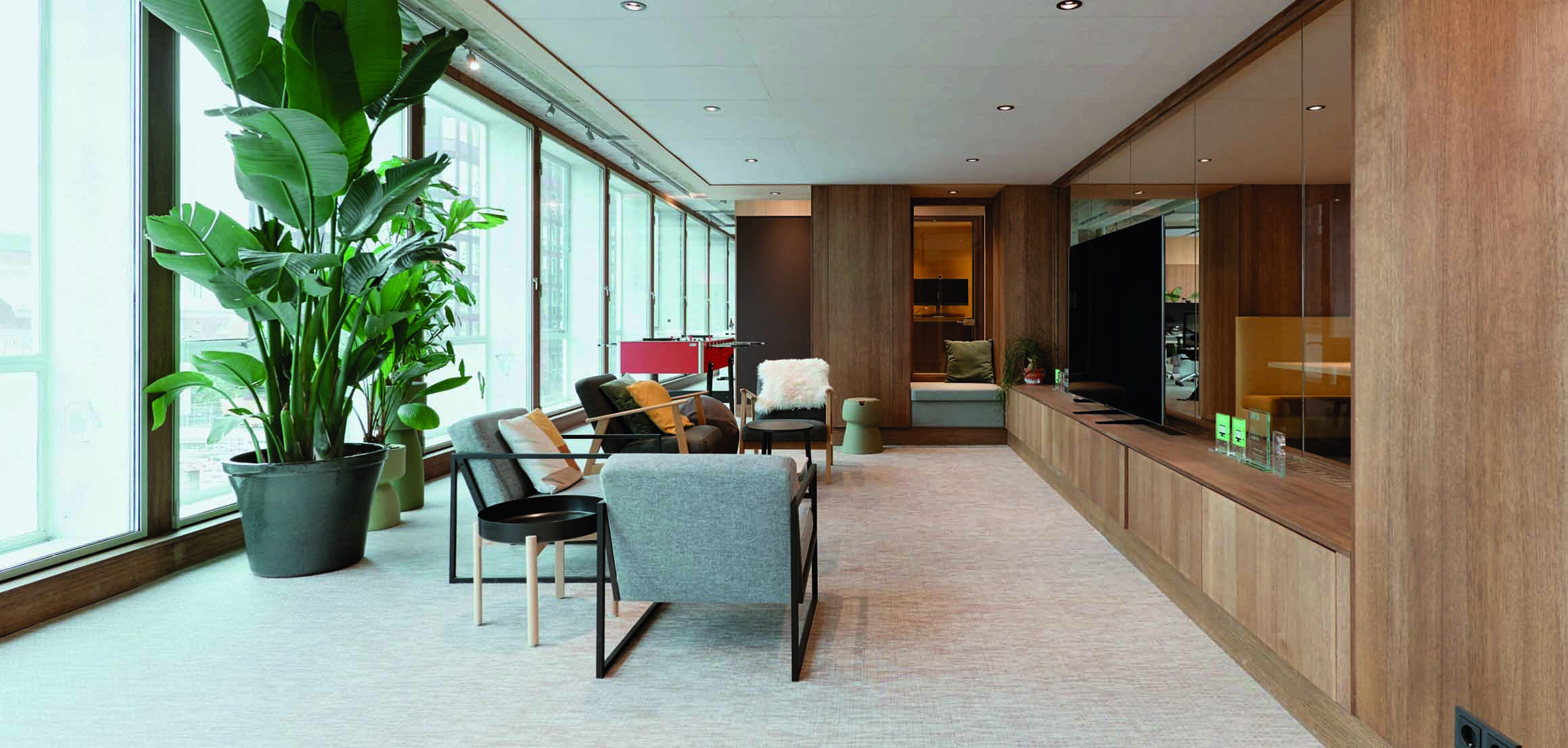 Lounge met fauteuils en planten in kantoor VI Company in Rotterdam