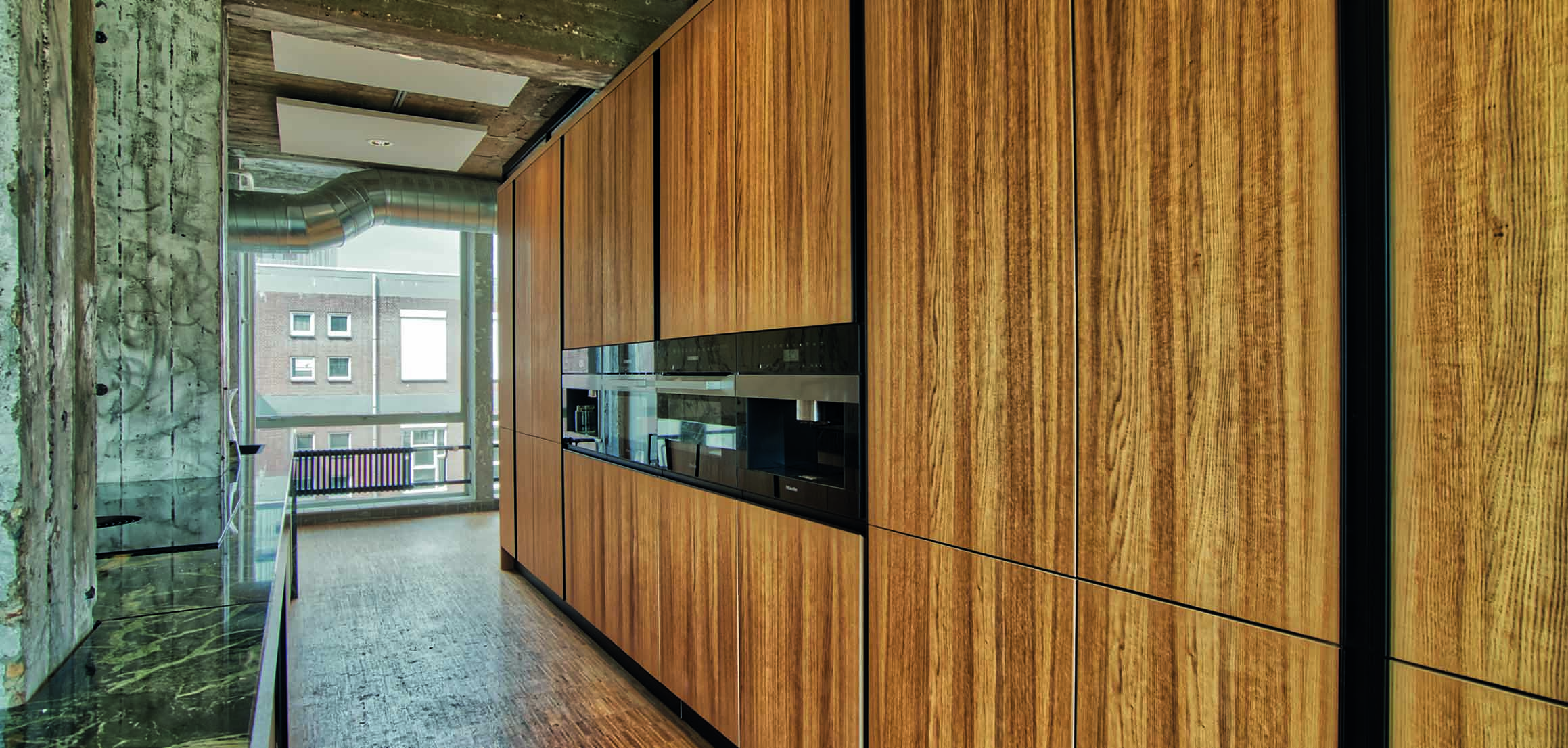 Houten keukenwand en marmeren eiland in architectenkantoor De Zwarte Hond in Rotterdam