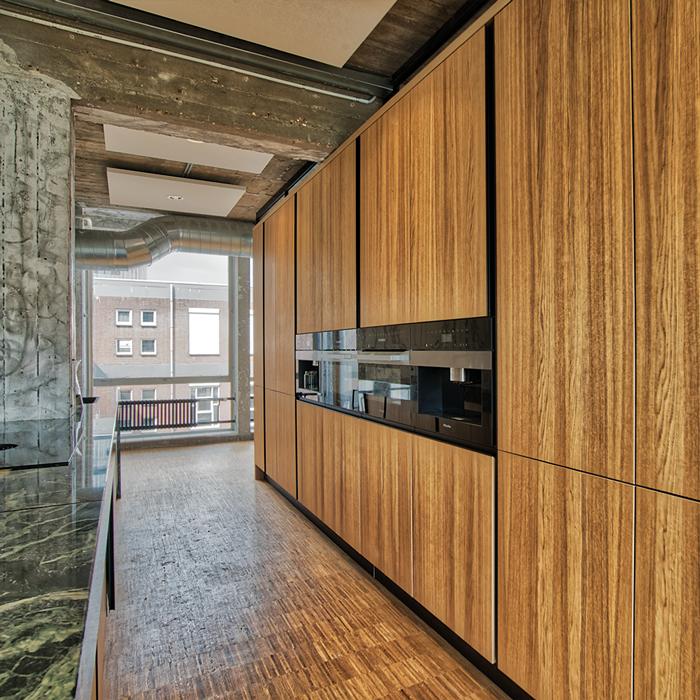 Houten keukenwand met inbouwapparatuur in architectenkantoor De Zwarte Hond in Rotterdam